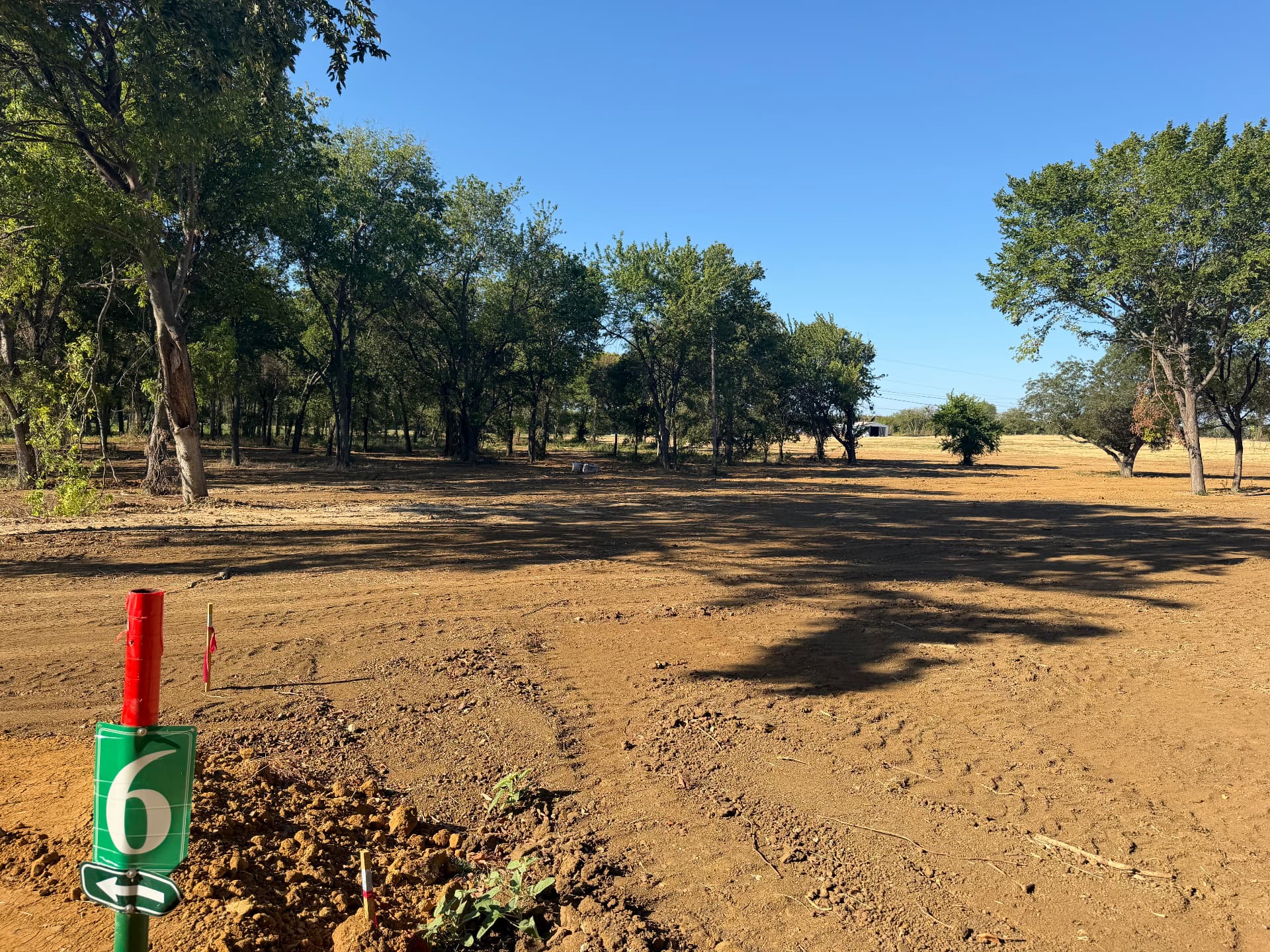 Lot 6 marker and tree-lined homesite at The Summer Meadows